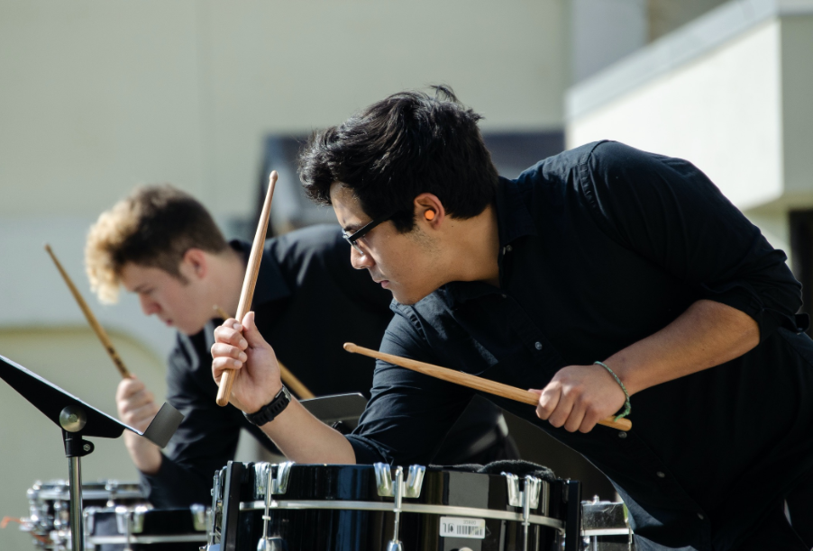 Music students in the percussion section playing the drums.